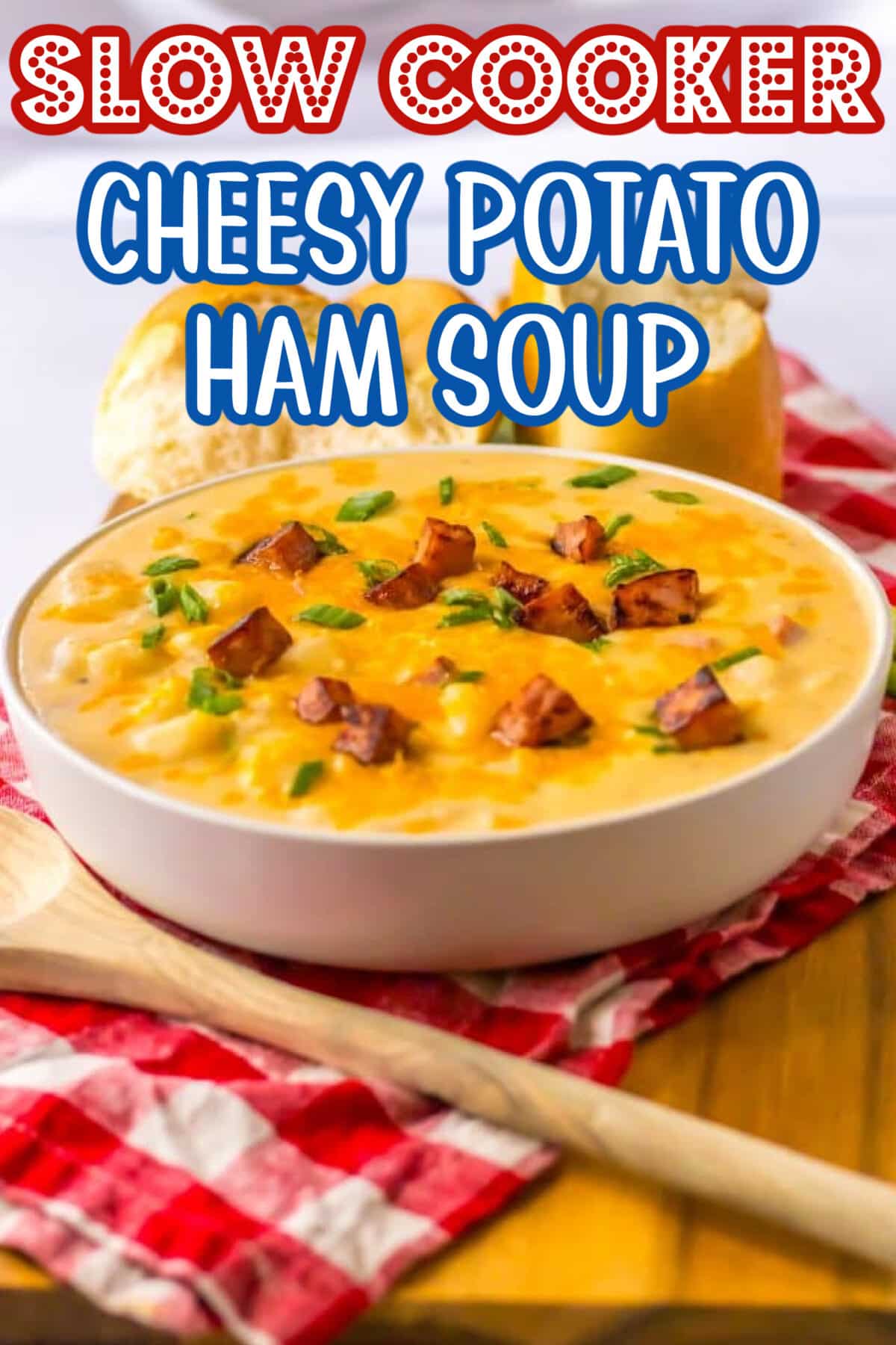 Bowl of creamy cheesy potato soup with chunks of ham, topped with shredded cheese and parsley.