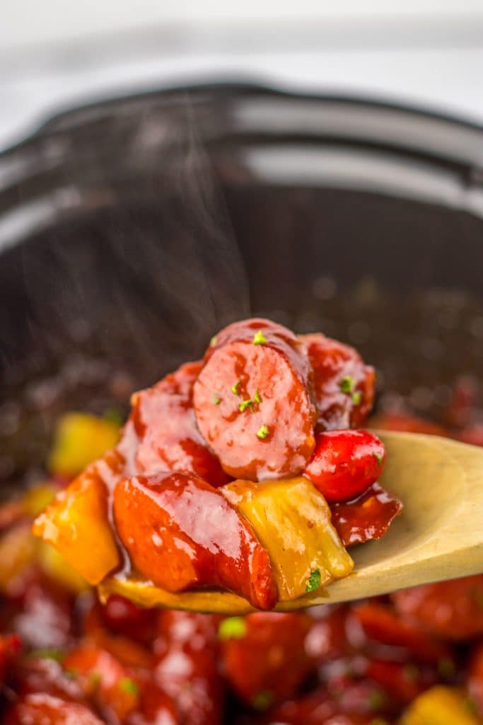 Slow Cooker Cranberry Pineapple Kielbasa Bites on spoon