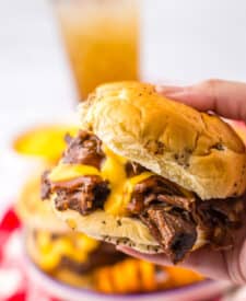 Slow Cooker Arbys Roast Beef and Cheddar Sandwiches in hand