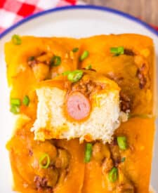 Mini chili cheese dog sliders baked on Hawaiian rolls with hot dogs, chili, melted cheddar cheese, and toppings, perfect for an easy weeknight dinner or game day appetizer.