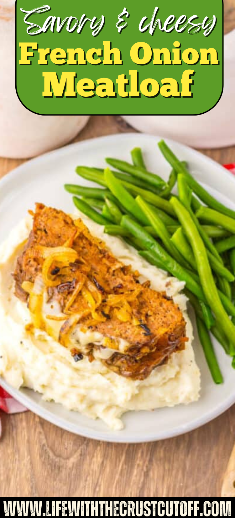 French Onion Meatloaf topped with melted cheese and caramelized onions served over mashed potatoes with green beans.