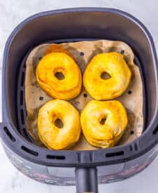 Air fryer basket with golden brown cooked doughnuts