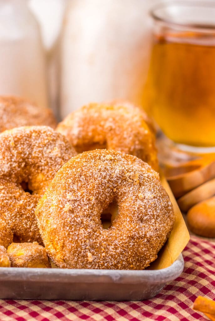 Close-up of air fryer doughnuts on red checkered towel, coated in cinnamon sugar