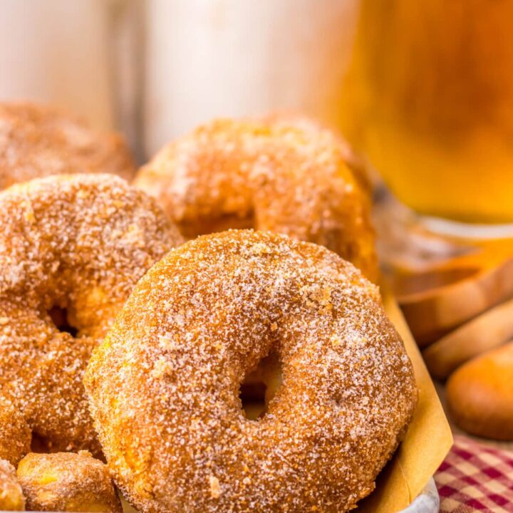 Close-up of air fryer doughnuts on red checkered towel, coated in cinnamon sugar
