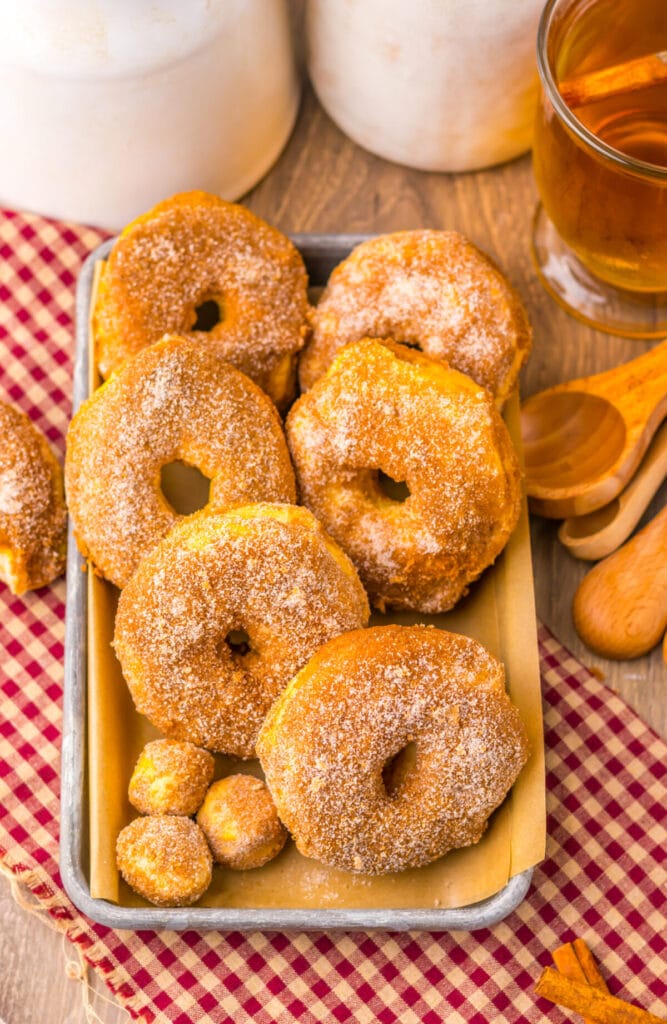 Close-up of air fryer doughnuts on red checkered towel, coated in cinnamon sugar