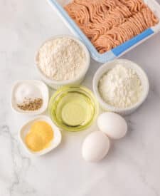 “Ingredients for copycat McDonald’s chicken nuggets including eggs, flour, and seasonings in bowls”