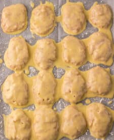 “Shaped raw chicken nuggets on parchment paper before frying”