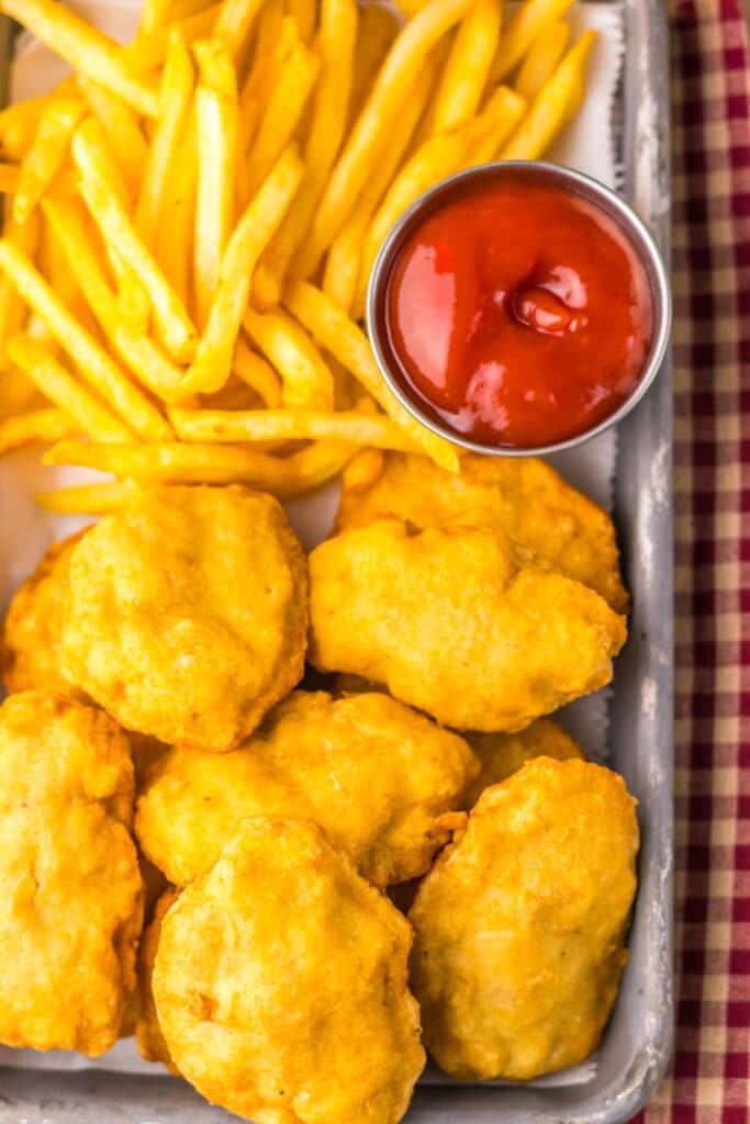 “Close-up of crispy chicken nuggets with dipping sauces”