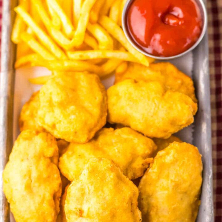 “Close-up of crispy chicken nuggets with dipping sauces”