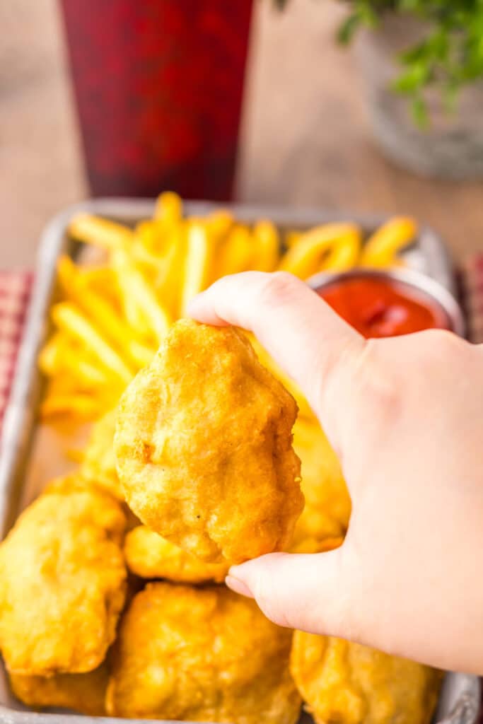 “Close-up of crispy chicken nuggets with dipping sauces”