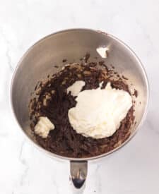 Chocolate cake with mousse layers being assembled for homemade Black Tie Mousse Cake."