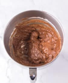 Chocolate cake with mousse layers being assembled for homemade Black Tie Mousse Cake."