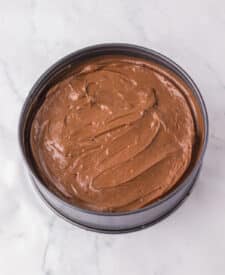 Chocolate cake with mousse layers being assembled for homemade Black Tie Mousse Cake."