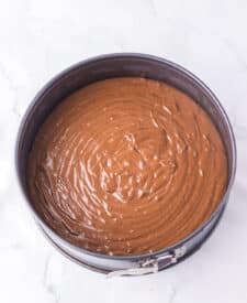 Chocolate cake with mousse layers being assembled for homemade Black Tie Mousse Cake."