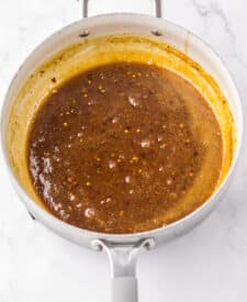 “Homemade orange sauce bubbling in a pan”
