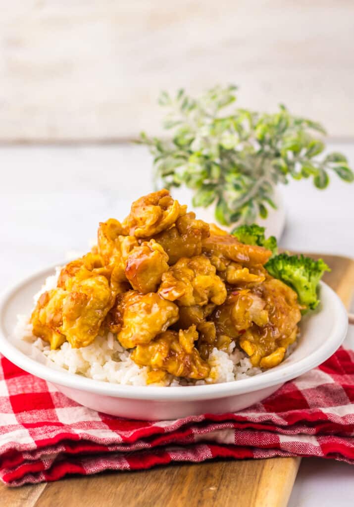 “Crispy Copycat Panda Express Orange Chicken served over white rice on a plate”