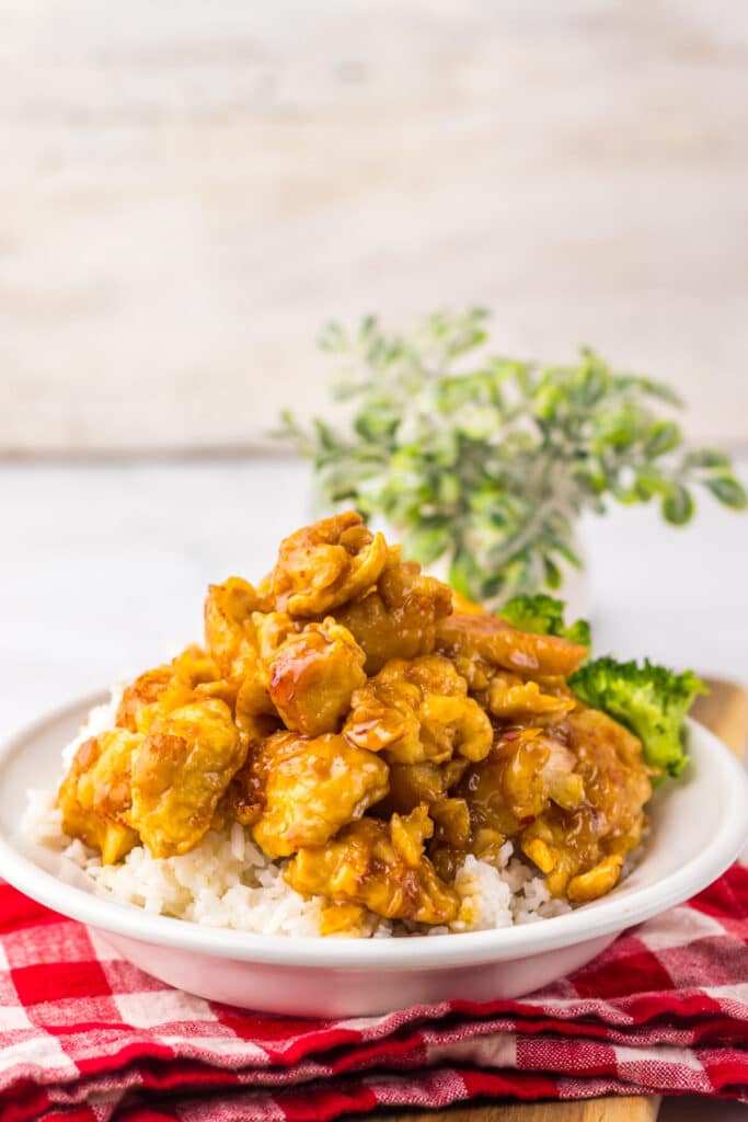 “Crispy Copycat Panda Express Orange Chicken served over white rice on a plate”