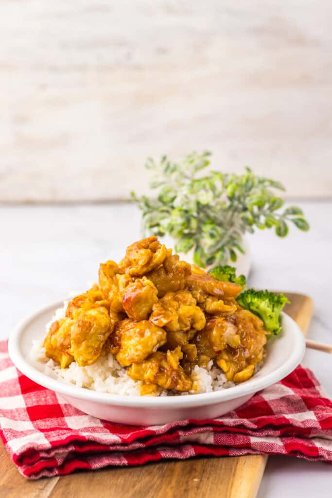 “Crispy Copycat Panda Express Orange Chicken served over white rice on a plate”