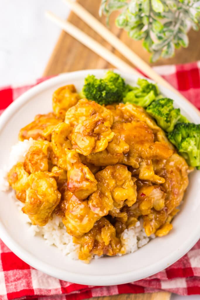 “Crispy Copycat Panda Express Orange Chicken served over white rice on a plate”