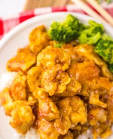 “Crispy Copycat Panda Express Orange Chicken served over white rice on a plate”