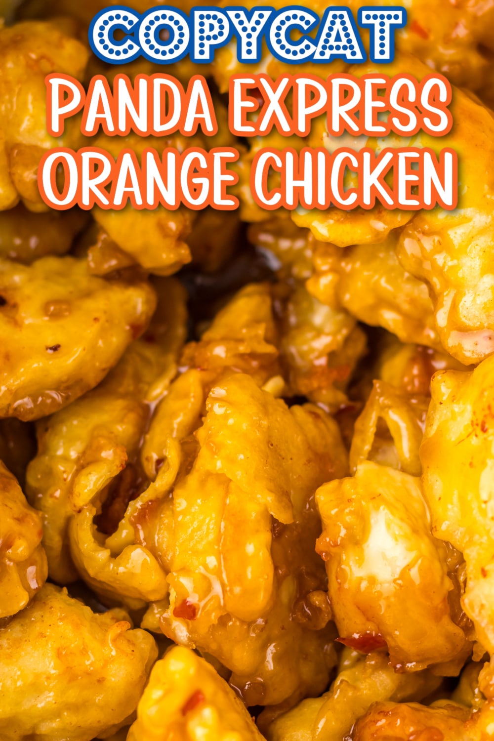 Crispy orange chicken coated in a sticky, tangy sauce served with white rice and green onions on a plate