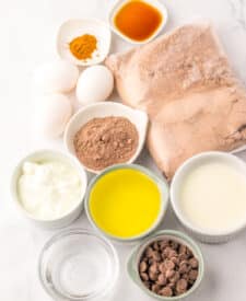 Jumbo Costco-style double chocolate muffins with melty chocolate chips on top, baked at home and cooling in liners on a wire rack.