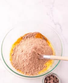 Jumbo Costco-style double chocolate muffins with melty chocolate chips on top, baked at home and cooling in liners on a wire rack.
