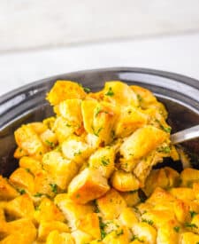 Overhead view of golden biscuit-topped chicken casserole in a slow cooker.