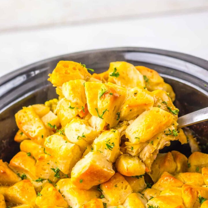 Overhead view of golden biscuit-topped chicken casserole in a slow cooker.