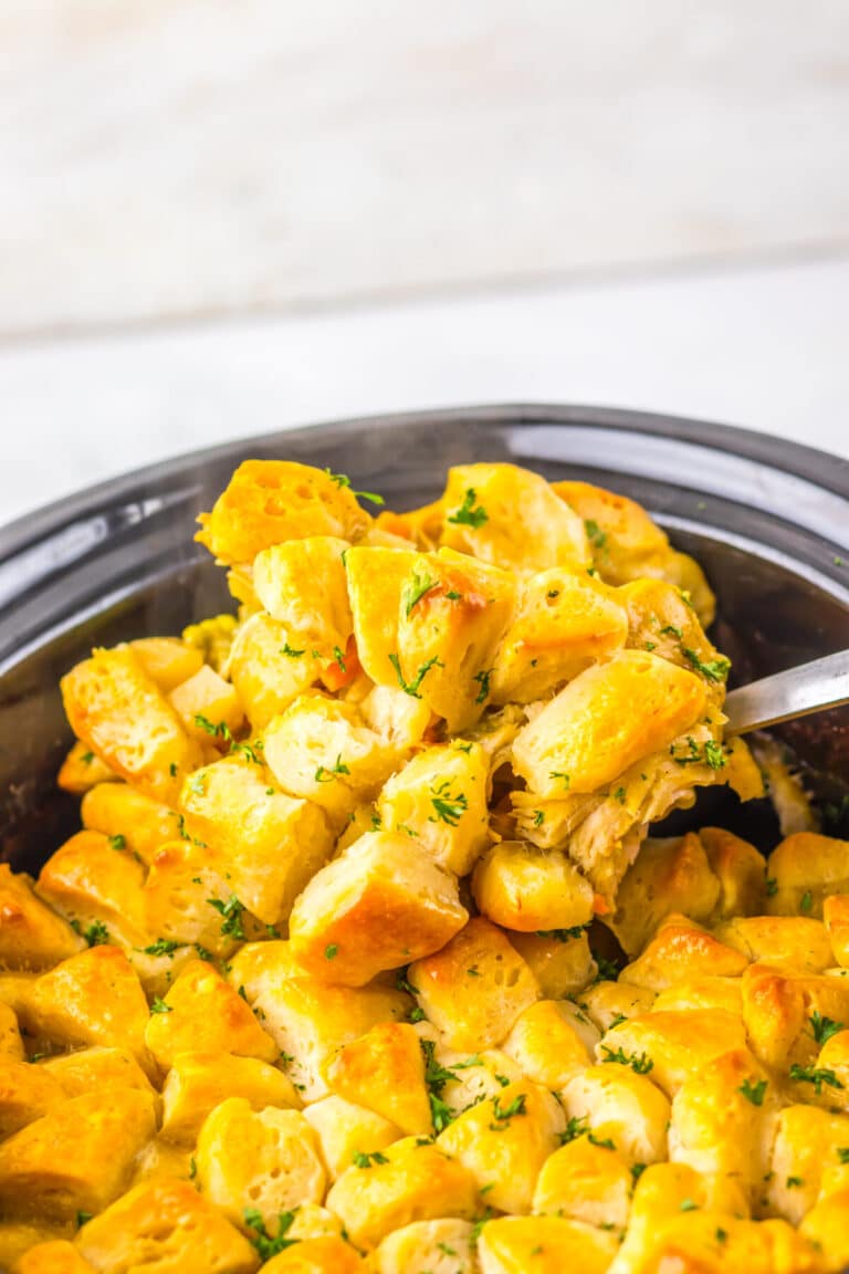 Overhead view of golden biscuit-topped chicken casserole in a slow cooker.
