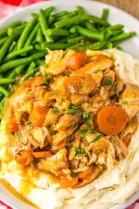 Slow cooker chicken pot roast with green beans and mashed potatoes on a plate