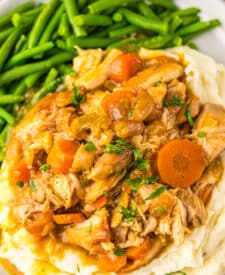 Slow cooker chicken pot roast with green beans and mashed potatoes on a plate