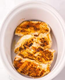 Overhead shot of seared chicken in slow cooker