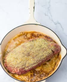 Juicy prime rib roast in pan with seasoned crust and au jus