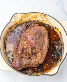 Juicy prime rib roast in pan with seasoned crust and au jus