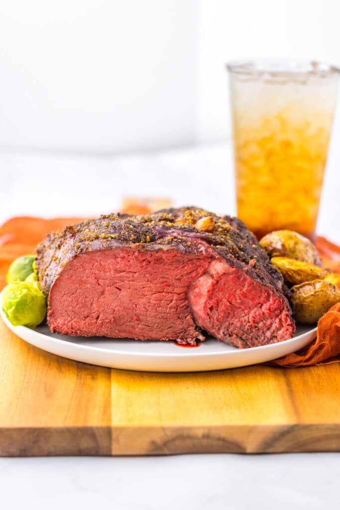 Whole cooked prime rib roast with crispy crust on cutting board