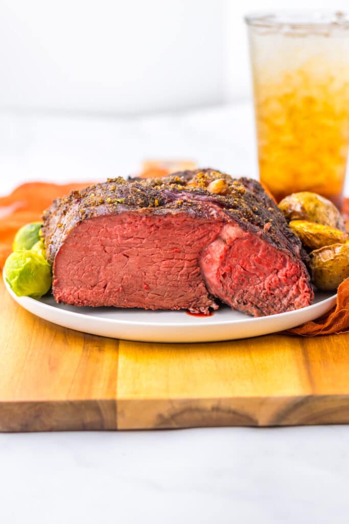 Whole cooked prime rib roast with crispy crust on cutting board
