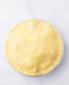 Unbaked pot pies with crimped edges in metal pie pans.