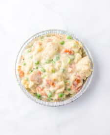 Pot pie filling with vegetables and chicken in a pie pan.