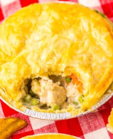 Chicken pot pie with scoop taken out showing creamy filling inside.