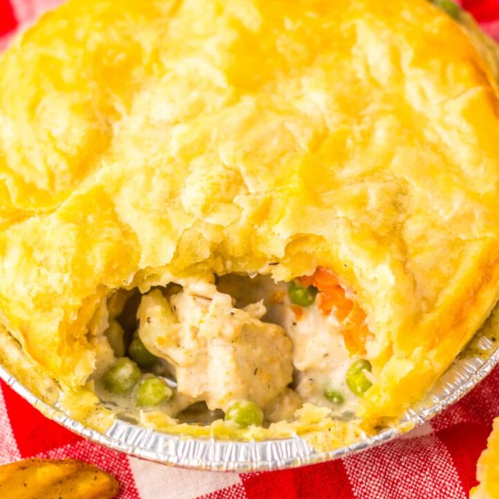 Chicken pot pie with scoop taken out showing creamy filling inside.