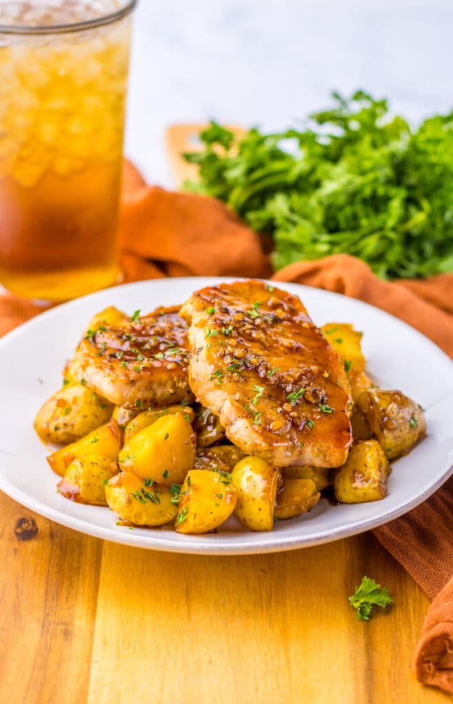 Dinner plate filled with juicy pork chops and tender baby potatoes in a sweet garlic soy glaze.
