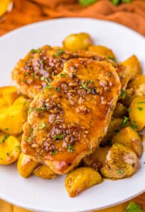 Close-up of juicy glazed pork chops and potatoes, covered in honey garlic sauce and ready to serve.