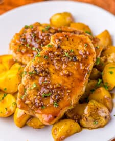 Close-up of juicy glazed pork chops and potatoes, covered in honey garlic sauce and ready to serve.