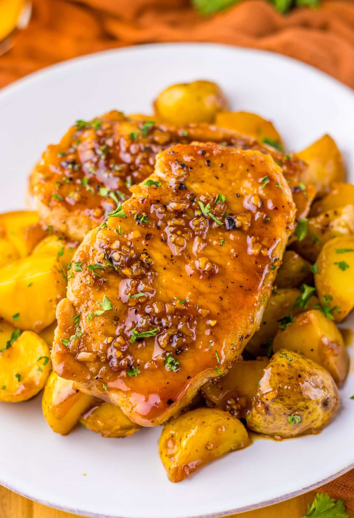 Close-up of juicy glazed pork chops and potatoes, covered in honey garlic sauce and ready to serve.
