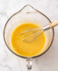 Butter and corn syrup whisked together in a clear glass mixing bowl