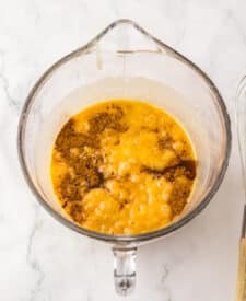 Brown sugar and granulated sugar mixed with butter and syrup in a glass bowl