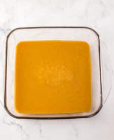 Smooth pumpkin spice caramel mixture spread in a rectangular baking dish