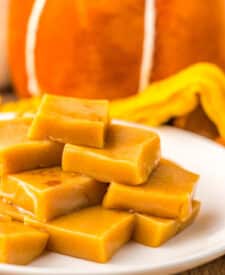 Chewy pumpkin spice caramels displayed on a white dish for fall dessert