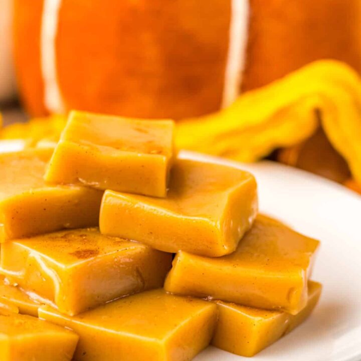 Chewy pumpkin spice caramels displayed on a white dish for fall dessert